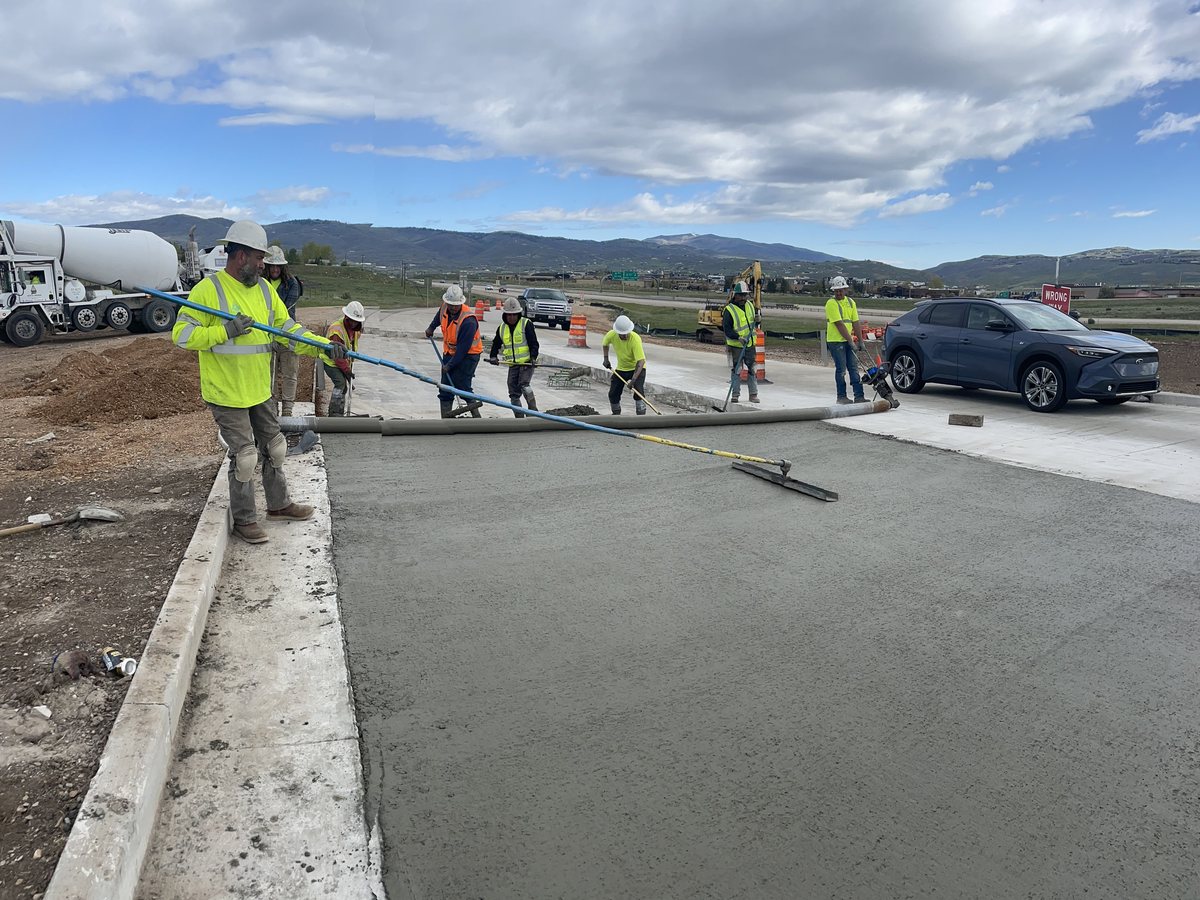 Fresh concrete being placed and screeded on a driveway pour