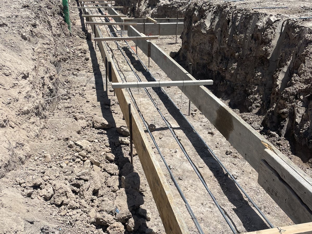 A crew forming and placing a structural concrete slab